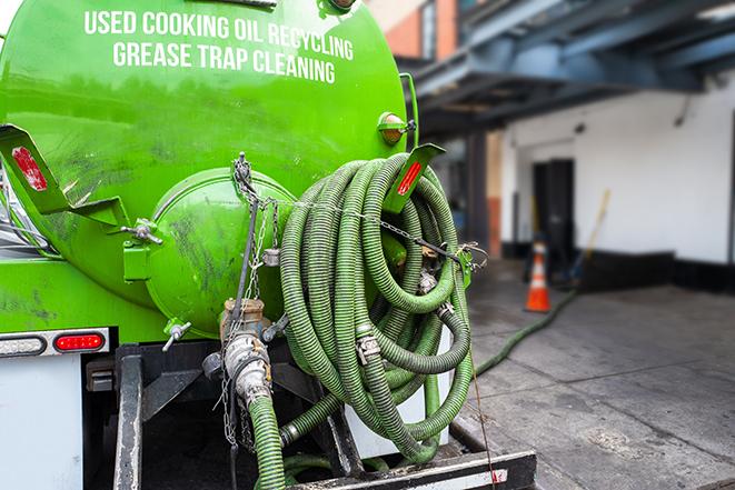 a technician pumping a grease trap in a commercial building in Lyndhurst